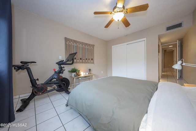 bedroom featuring ceiling fan, a closet, and light tile patterned floors