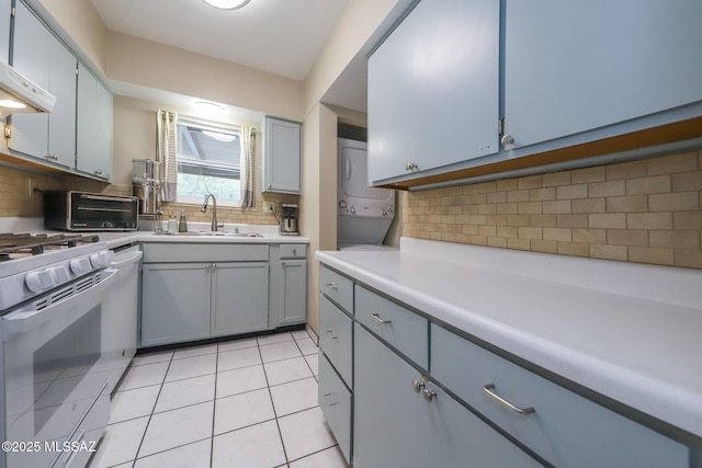 kitchen featuring light tile patterned flooring, sink, stacked washer and dryer, exhaust hood, and white appliances