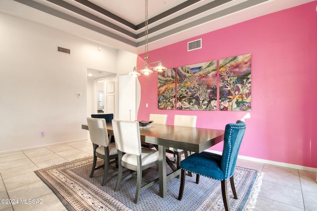 dining area with light tile patterned flooring, a towering ceiling, visible vents, and baseboards