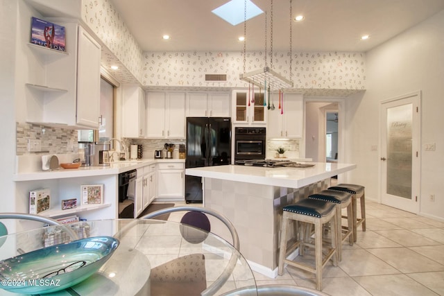 kitchen featuring open shelves, a sink, a kitchen island, light countertops, and black appliances