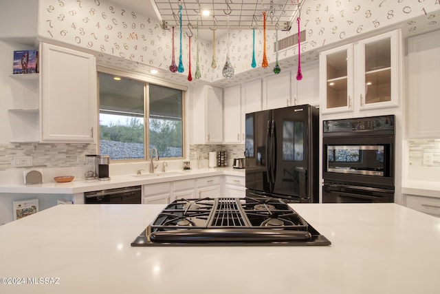 kitchen with white cabinets, a sink, black appliances, and open shelves