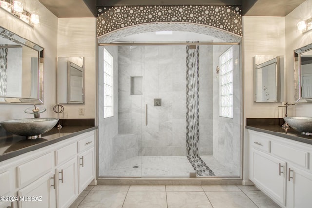 bathroom with tile patterned flooring, a shower stall, and vanity