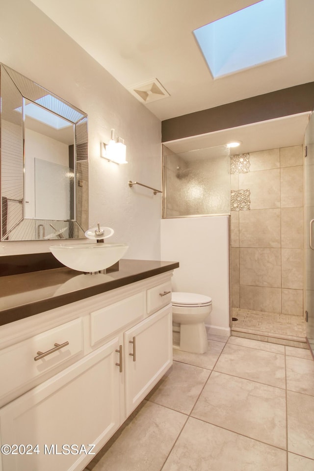 full bath with a skylight, visible vents, toilet, vanity, and tiled shower