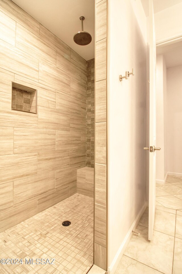 bathroom featuring tiled shower and baseboards