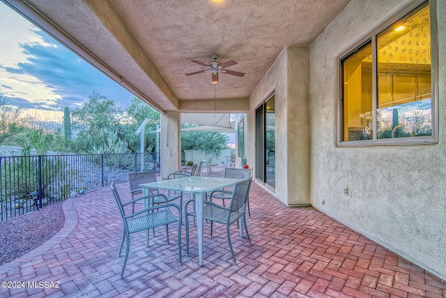 view of patio / terrace with fence, a ceiling fan, and outdoor dining space