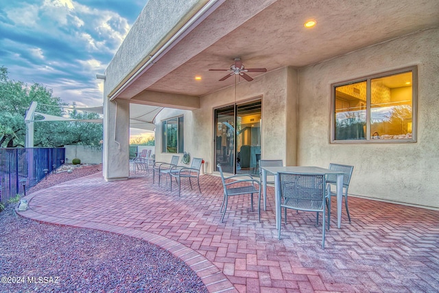 view of patio / terrace with outdoor dining space, fence, and a ceiling fan