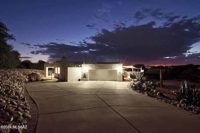 view of front facade with driveway, an attached garage, and stucco siding