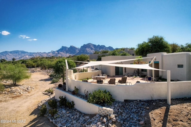 back of house featuring fence private yard, a patio area, a mountain view, and stucco siding