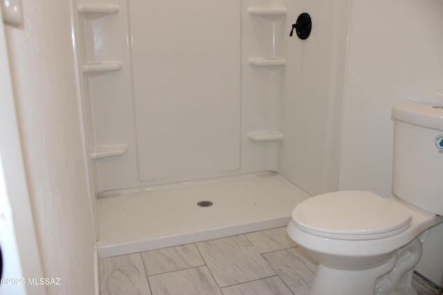 bathroom featuring a shower and toilet