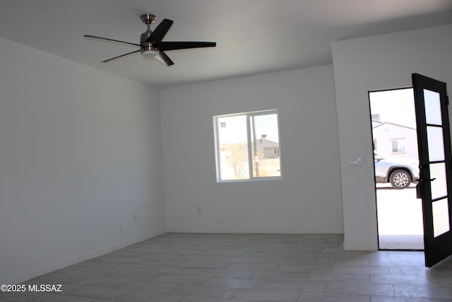 empty room featuring baseboards and ceiling fan