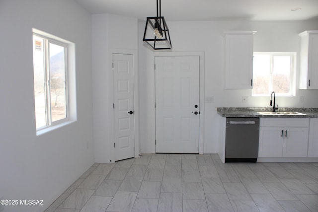 kitchen featuring pendant lighting, a sink, stainless steel dishwasher, dark stone counters, and white cabinets