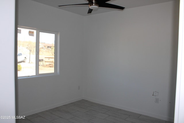 unfurnished room featuring a ceiling fan and baseboards