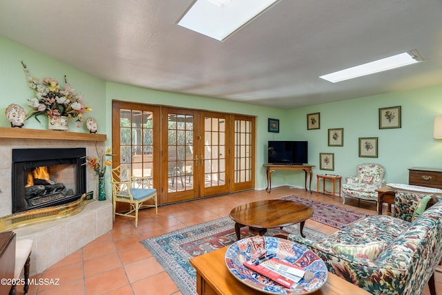 living room featuring a skylight, light tile patterned floors, and french doors