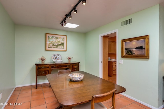 tiled dining area with rail lighting and a skylight