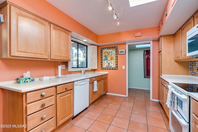 kitchen featuring light tile patterned floors, light brown cabinetry, track lighting, and white appliances