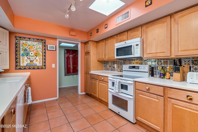 kitchen with white appliances, light brown cabinets, tasteful backsplash, rail lighting, and light tile patterned floors