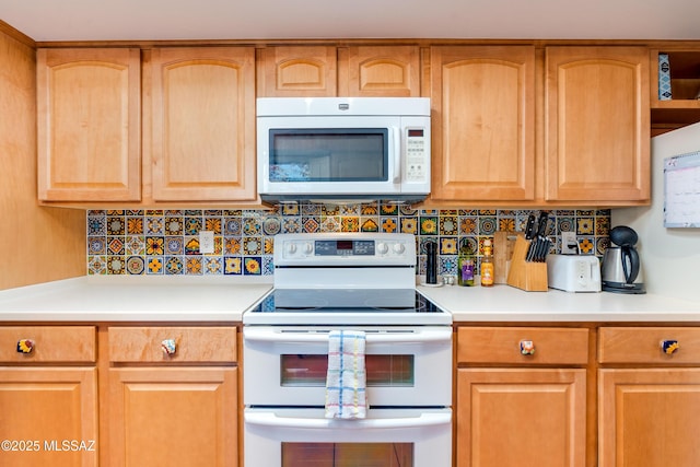 kitchen featuring decorative backsplash and white appliances