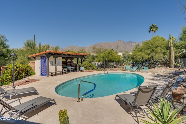 view of swimming pool with a mountain view and a patio