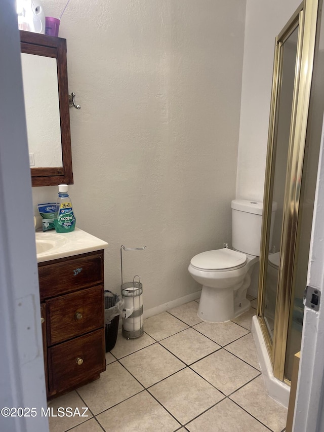 bathroom featuring tile patterned flooring, vanity, an enclosed shower, and toilet