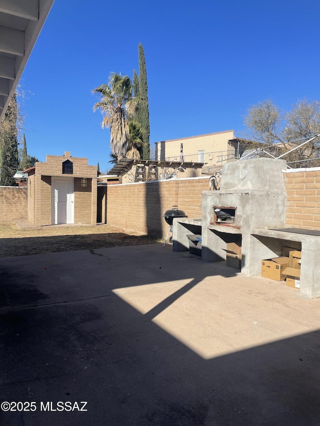 view of yard with an outdoor fireplace, an outdoor structure, and a patio area