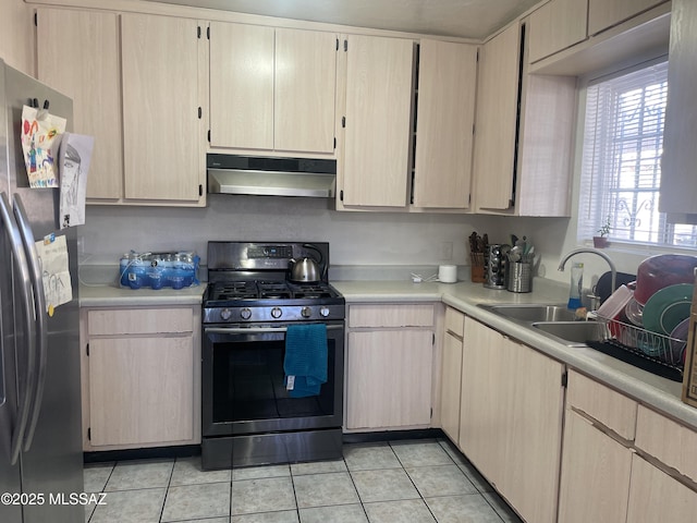 kitchen featuring appliances with stainless steel finishes, light brown cabinets, light tile patterned floors, and sink