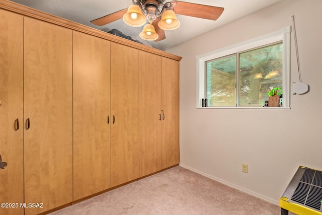 unfurnished bedroom featuring ceiling fan, light colored carpet, and a closet