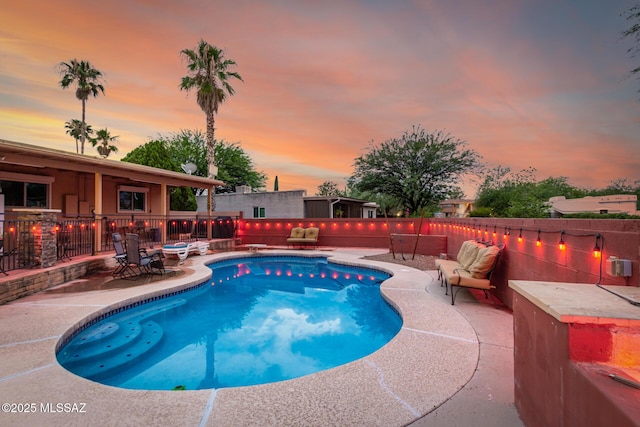 pool at dusk with a patio