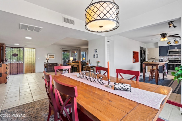 tiled dining space with ceiling fan and a healthy amount of sunlight