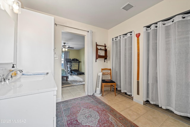 bathroom with tile patterned flooring, vanity, and ceiling fan