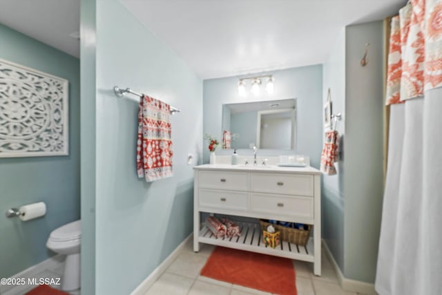 bathroom with toilet, vanity, and tile patterned floors