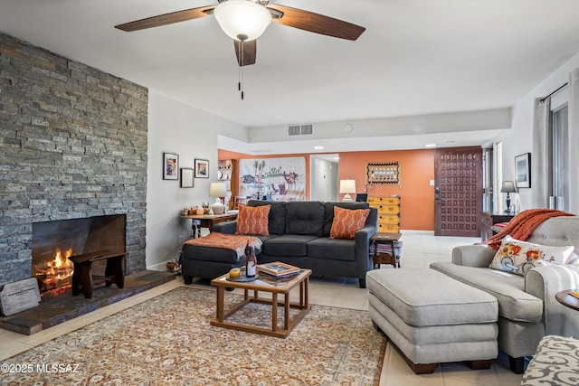 living room featuring a fireplace, light tile patterned floors, and ceiling fan