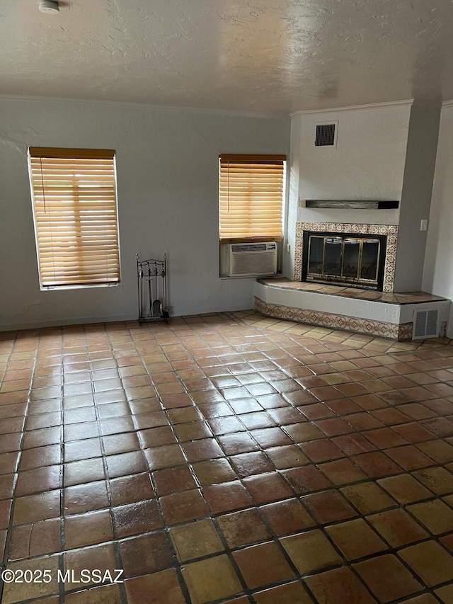 unfurnished living room featuring tile patterned flooring, a textured ceiling, and cooling unit