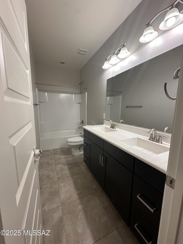 full bath featuring toilet, a sink, double vanity, and tub / shower combination