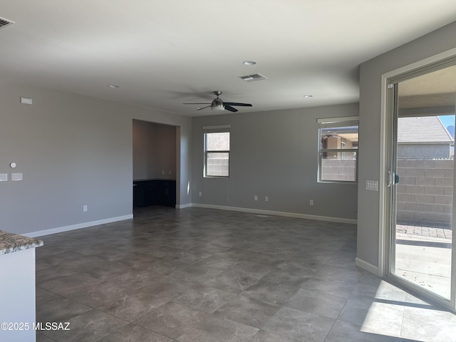 unfurnished living room featuring a ceiling fan, baseboards, and visible vents