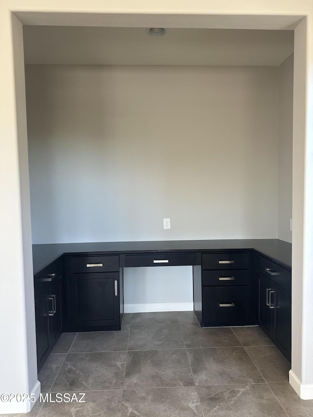 unfurnished office featuring built in desk