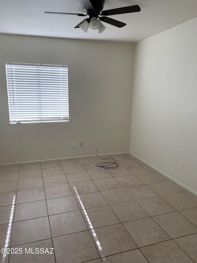 tiled empty room featuring ceiling fan