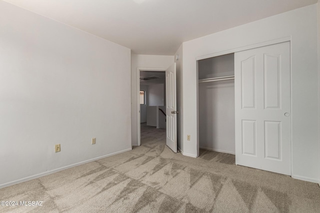 unfurnished bedroom with light carpet and a closet