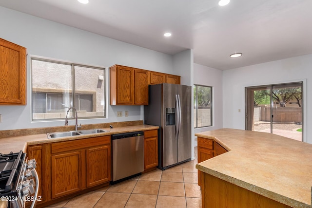 kitchen featuring light tile patterned floors, stainless steel appliances, and sink