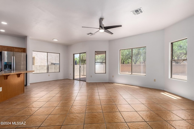 unfurnished living room featuring tile patterned floors and ceiling fan