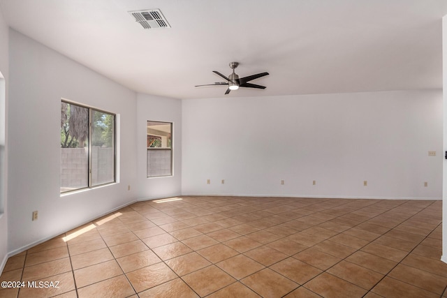 tiled empty room featuring ceiling fan