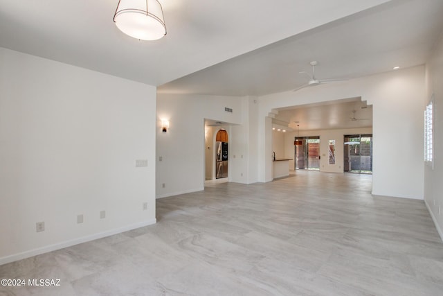 empty room with ceiling fan and vaulted ceiling