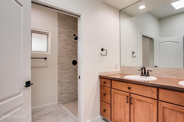 bathroom with decorative backsplash, vanity, and tiled shower