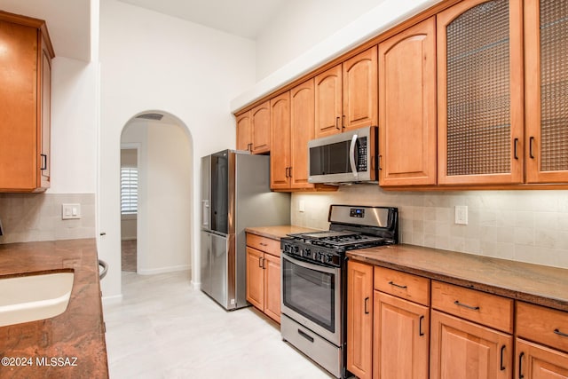 kitchen with tasteful backsplash, sink, and appliances with stainless steel finishes