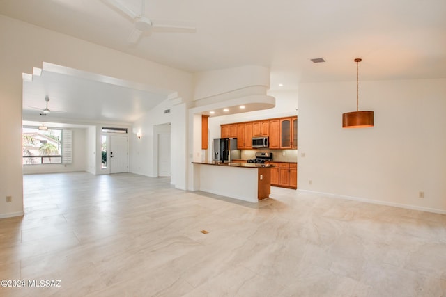 kitchen featuring pendant lighting, lofted ceiling, ceiling fan, kitchen peninsula, and stainless steel appliances