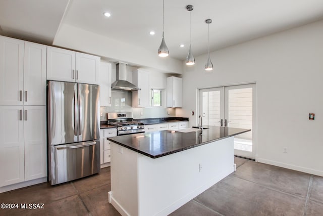 kitchen with a center island, wall chimney exhaust hood, decorative light fixtures, white cabinetry, and stainless steel appliances