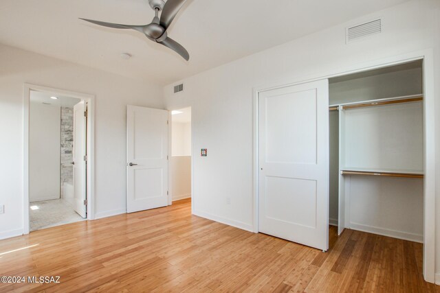 unfurnished bedroom with ceiling fan, light wood-type flooring, connected bathroom, and a closet