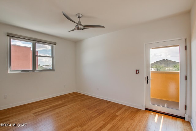 spare room with plenty of natural light, light hardwood / wood-style floors, and ceiling fan