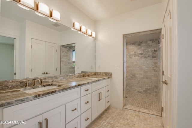 bathroom with a tile shower and vanity