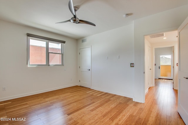 empty room with light hardwood / wood-style floors, ceiling fan, and a healthy amount of sunlight