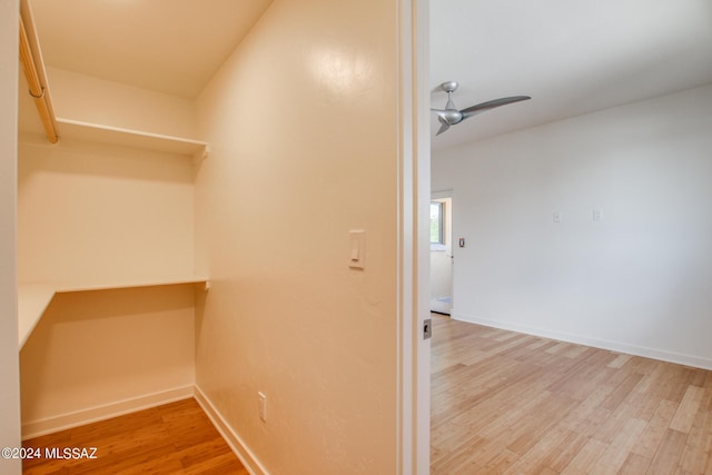 walk in closet with hardwood / wood-style flooring and ceiling fan